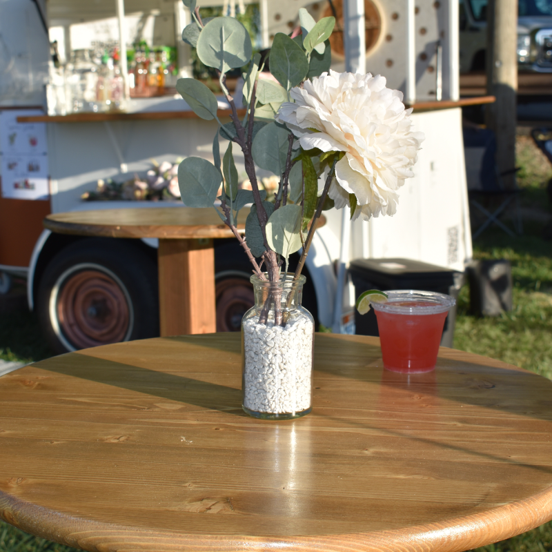 Close up photo of a flower tablepiece in front of the Wandering Jade Trailer.
