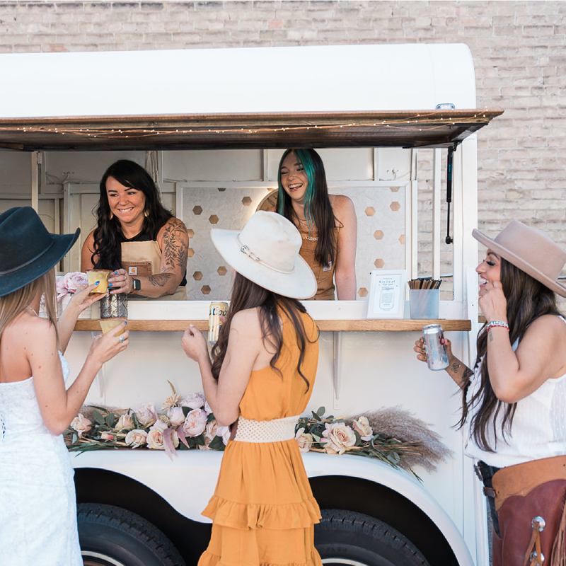 Photo of the Wandering Jade Trailer with bartenders serving drinks.