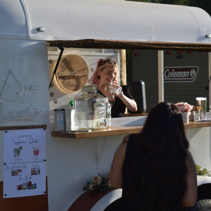 Photo of Harley (Bartender) mixxing drinks behind the counter.